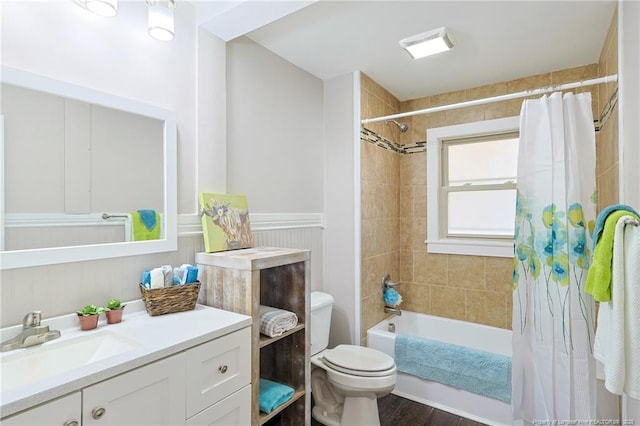 full bathroom with toilet, shower / bathtub combination with curtain, hardwood / wood-style floors, and vanity