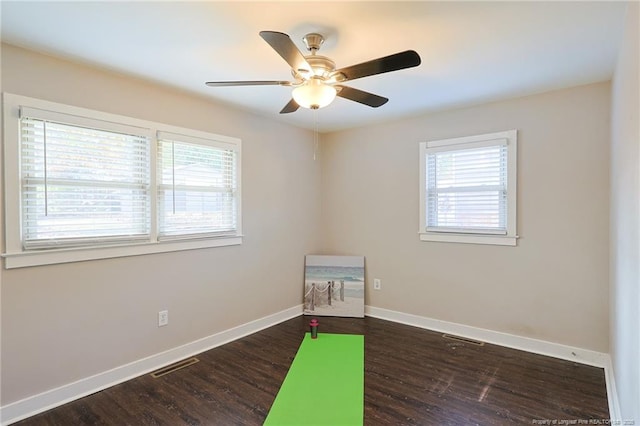 empty room with ceiling fan and dark hardwood / wood-style floors