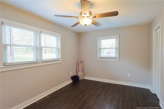 spare room featuring dark wood-type flooring and ceiling fan