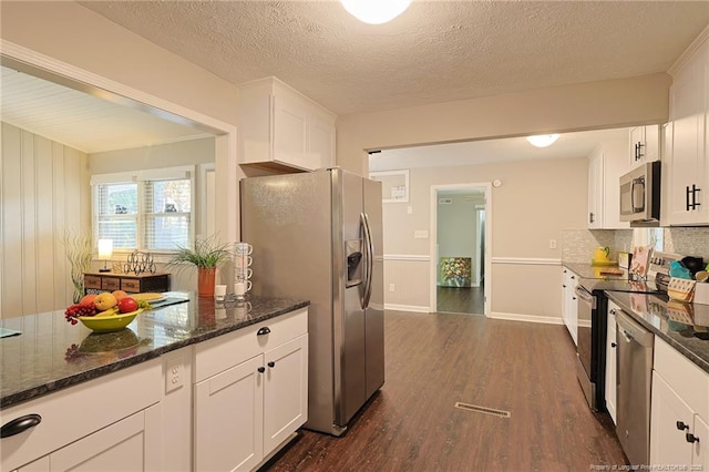 kitchen featuring dark hardwood / wood-style flooring, white cabinetry, appliances with stainless steel finishes, a textured ceiling, and dark stone counters