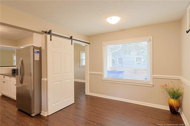 interior space with a barn door and dark hardwood / wood-style flooring