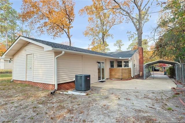 rear view of property with central air condition unit and a carport