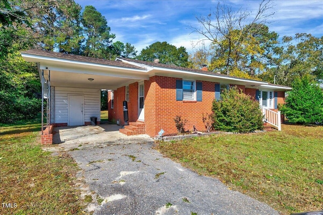 ranch-style home featuring a front yard and a carport