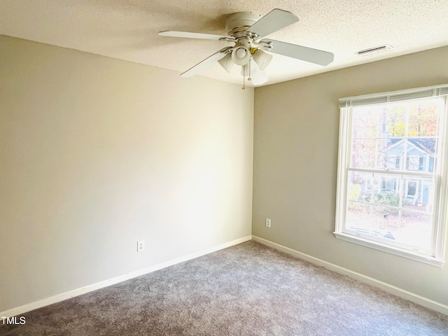 carpeted spare room featuring ceiling fan and a textured ceiling