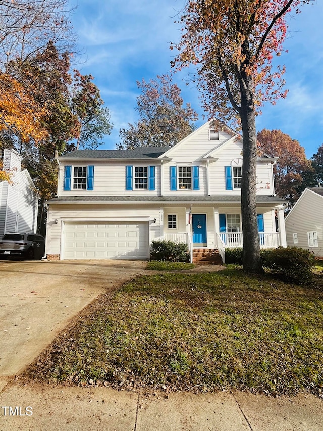 view of front of property featuring covered porch, a garage, and a front lawn