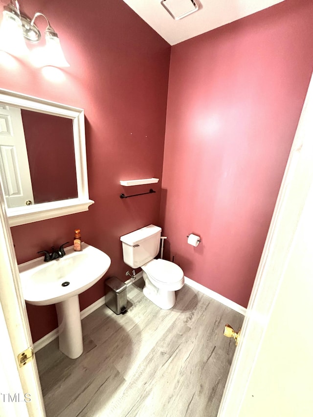 bathroom with wood-type flooring and toilet