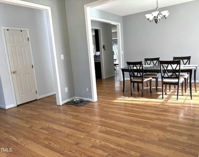 dining area featuring hardwood / wood-style floors and a chandelier