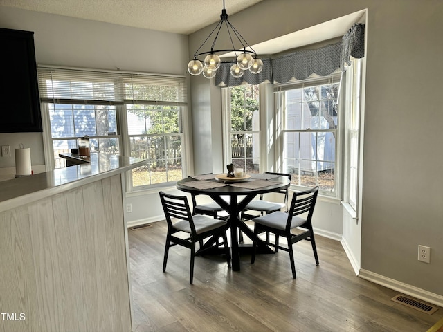 dining room featuring hardwood / wood-style floors, a chandelier, and a textured ceiling