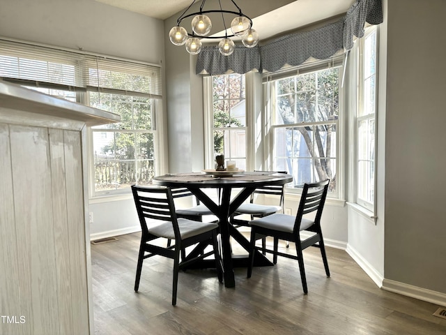 dining area with dark hardwood / wood-style flooring and a notable chandelier