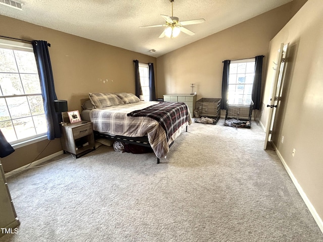 bedroom featuring a textured ceiling, vaulted ceiling, ceiling fan, and carpet