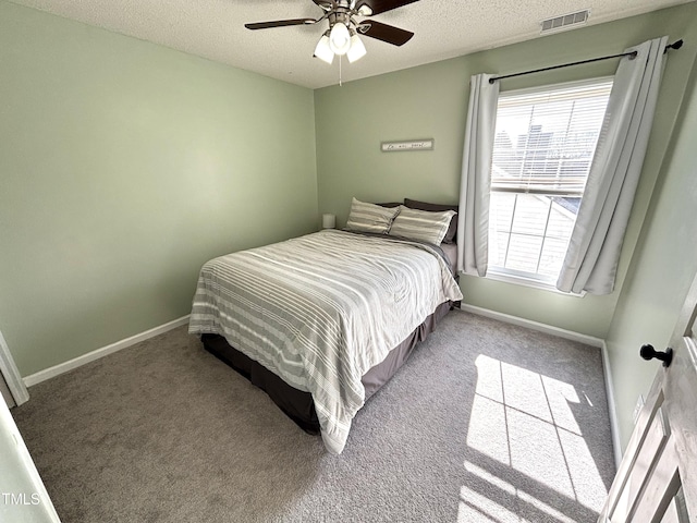 carpeted bedroom featuring a textured ceiling and ceiling fan