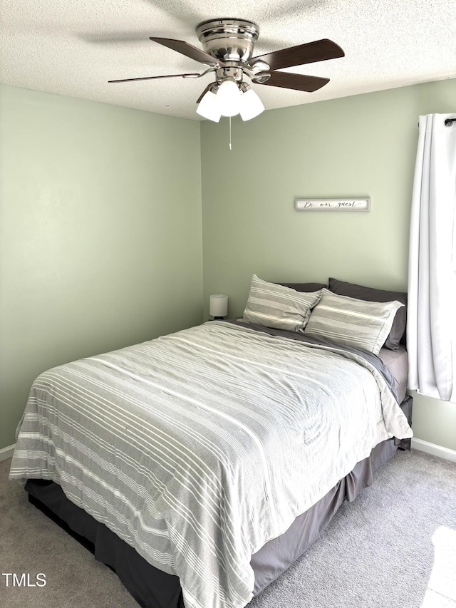 bedroom with carpet, a textured ceiling, and ceiling fan