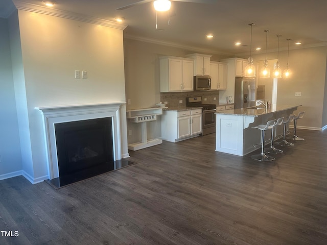 kitchen with a kitchen island with sink, dark wood-type flooring, white cabinets, and stainless steel appliances