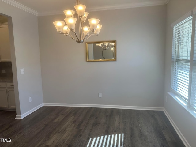 spare room featuring a chandelier, dark wood-type flooring, and ornamental molding