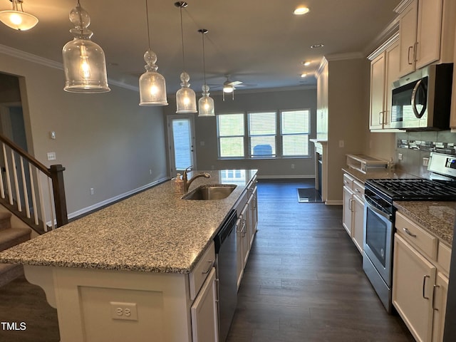 kitchen featuring a center island with sink, sink, ceiling fan, appliances with stainless steel finishes, and decorative light fixtures