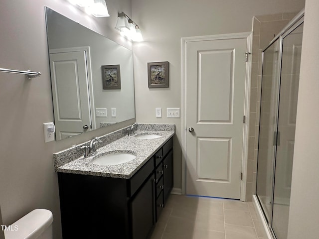 bathroom with tile patterned flooring, vanity, toilet, and a shower with door