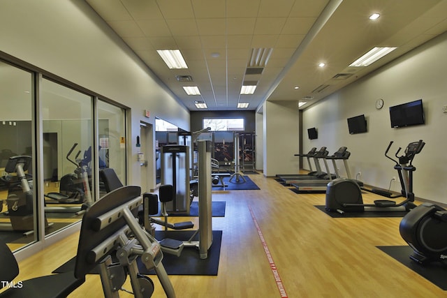 workout area with a drop ceiling and light hardwood / wood-style floors