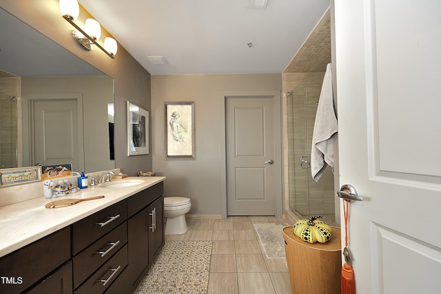 bathroom featuring tile patterned flooring, vanity, toilet, and walk in shower