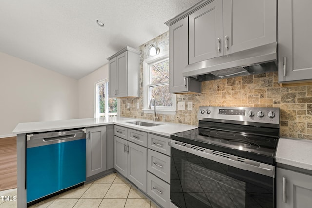 kitchen with tasteful backsplash, stainless steel appliances, sink, light tile patterned floors, and gray cabinets