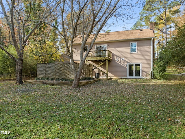 rear view of property featuring a yard and a deck