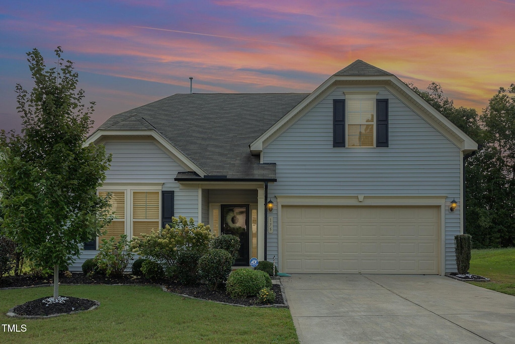 view of front facade featuring a garage and a lawn