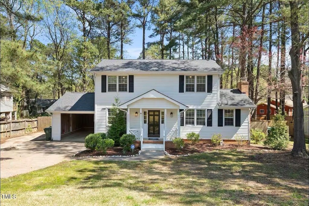 colonial house with covered porch and a carport