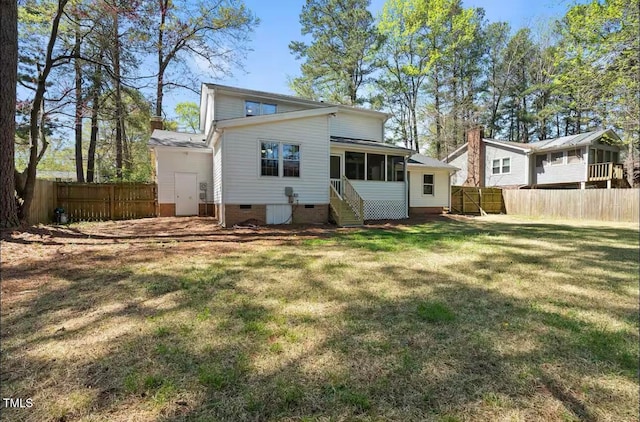 rear view of house with a lawn and a sunroom