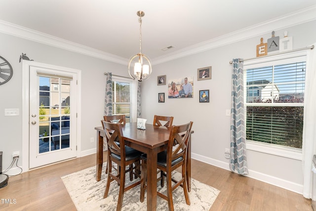 dining room featuring a chandelier, wood-type flooring, and ornamental molding