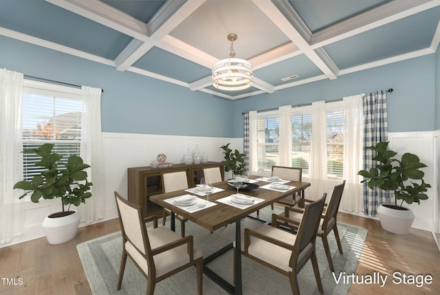 dining area with beam ceiling, hardwood / wood-style floors, coffered ceiling, and an inviting chandelier