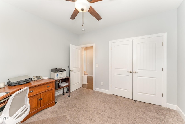 carpeted office space with ceiling fan