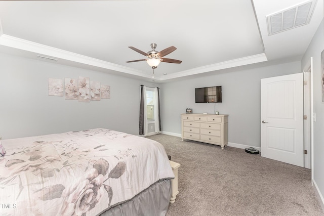 carpeted bedroom with a raised ceiling, ceiling fan, and ornamental molding