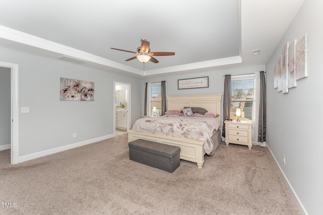 carpeted bedroom featuring ceiling fan, crown molding, connected bathroom, and a tray ceiling