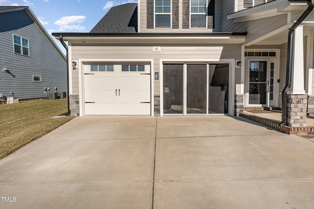 view of front of home with a garage, central air condition unit, and a front lawn