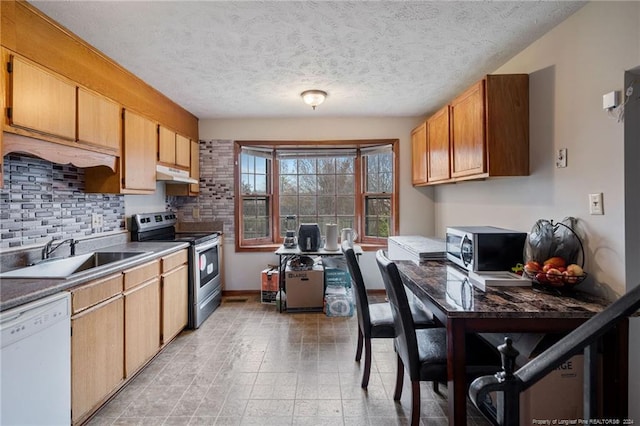 kitchen featuring appliances with stainless steel finishes, a textured ceiling, tasteful backsplash, and sink