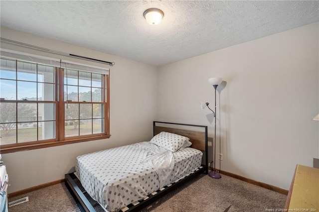 bedroom with carpet and a textured ceiling