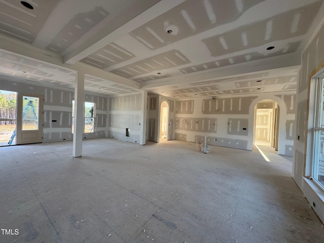 unfurnished living room featuring arched walkways