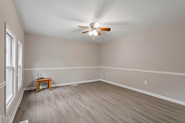 spare room with ceiling fan and light wood-type flooring