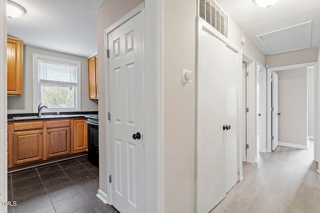 corridor featuring sink and dark tile patterned floors