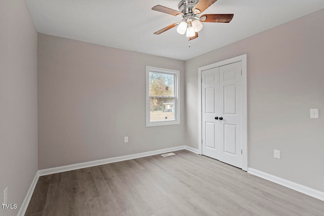 unfurnished bedroom with a closet, light hardwood / wood-style floors, and ceiling fan