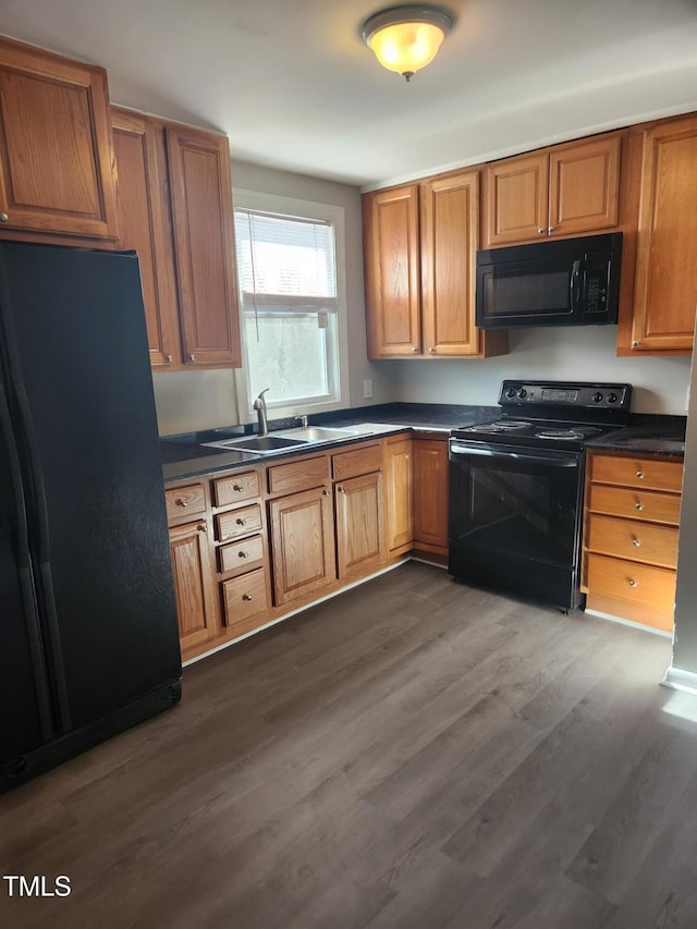 kitchen featuring dark wood-type flooring, sink, and black appliances