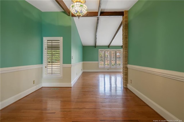 bonus room with hardwood / wood-style flooring, lofted ceiling with beams, and a notable chandelier