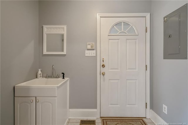 entrance foyer with electric panel, sink, and light tile patterned flooring