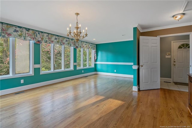 unfurnished dining area with crown molding, a chandelier, and light wood-type flooring