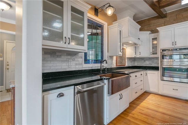 kitchen with white cabinets, appliances with stainless steel finishes, decorative backsplash, and sink