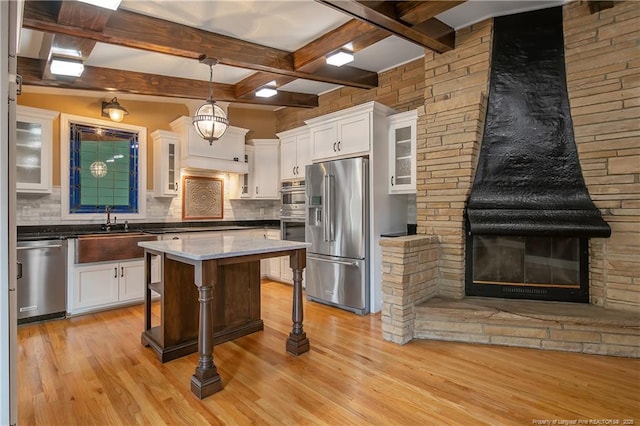 kitchen with white cabinets, backsplash, and stainless steel appliances