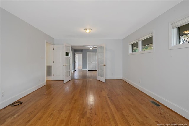 empty room with french doors, light hardwood / wood-style flooring, and ceiling fan