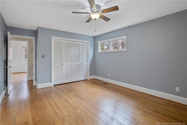 unfurnished bedroom featuring ceiling fan, light wood-type flooring, and a closet