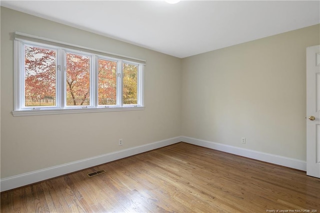 unfurnished room with hardwood / wood-style flooring