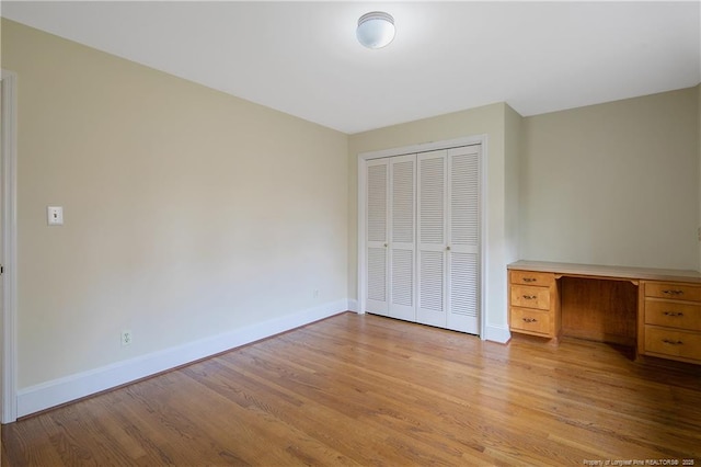 unfurnished bedroom featuring light hardwood / wood-style flooring and a closet