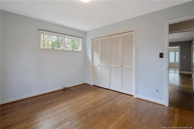 unfurnished bedroom featuring a closet and hardwood / wood-style flooring